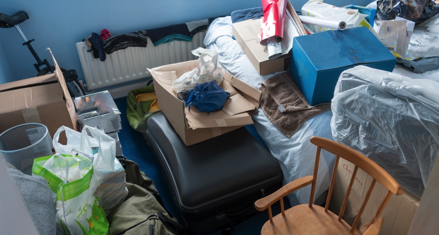 Bedroom with bags and boxes before Farmington Hills cleanup sorting